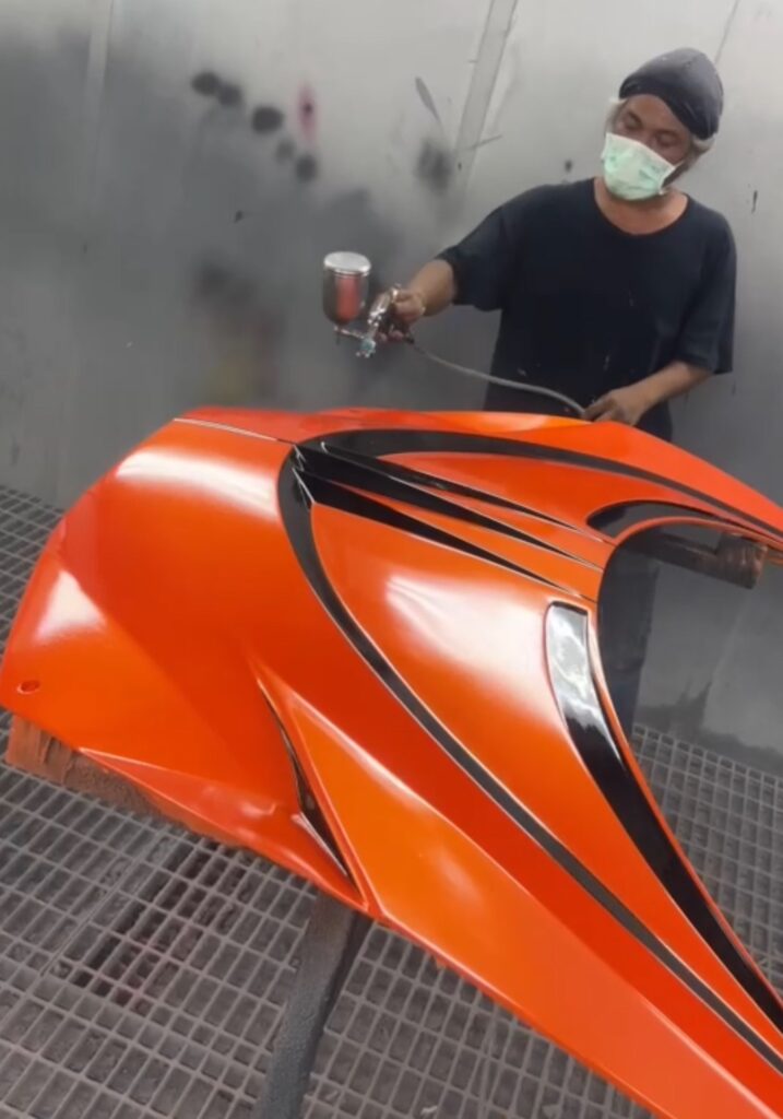 Jetcar body undergoing professional automotive-grade paint finishing.